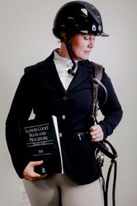 Photo of Corinne Mitchell in wearing equine uniform.